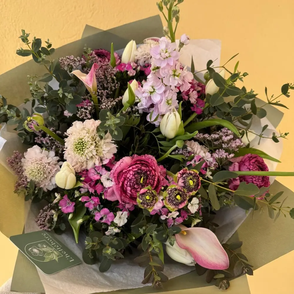 Bouquet de fleurs dans les tons Rose foncé et clair avec feuillage d'eucalyptus