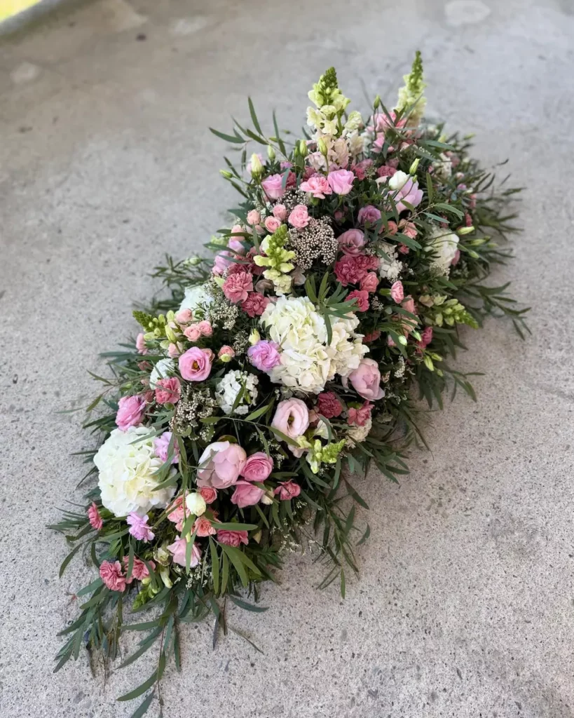 Dessus de cercueil tons pastels mélange d'hortensia de roses de lisianthus de mini oeillets