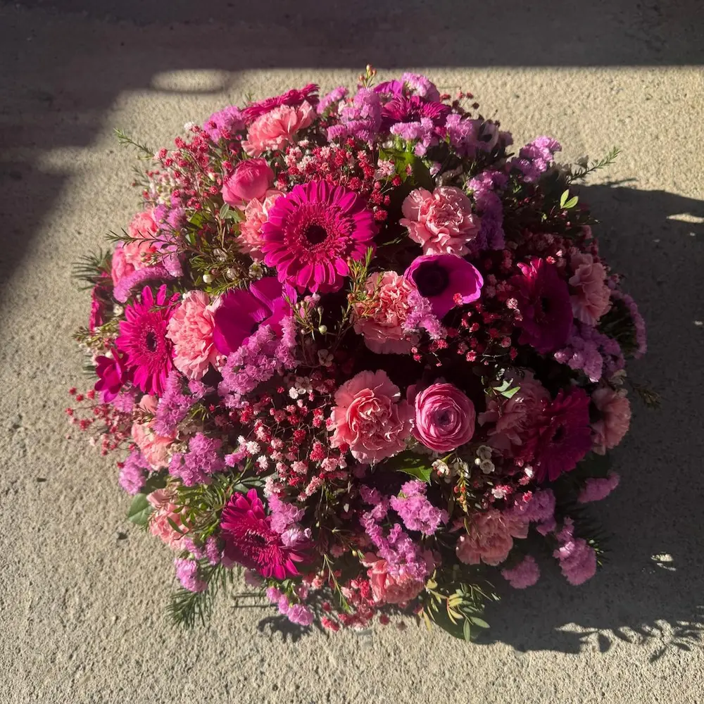 Coussin rond de fleurs dans les tons rose et fuchsia